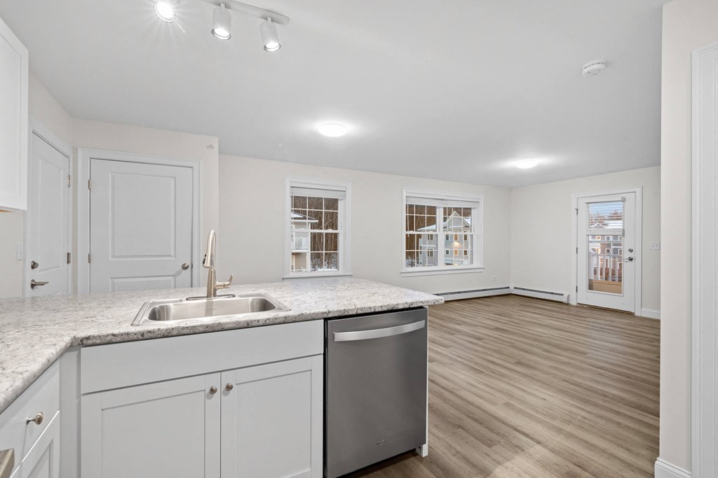 a renovated kitchen with white cabinets and a stainless steel sink