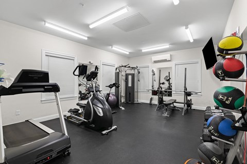 a gym with cardio equipment and weights on the floor