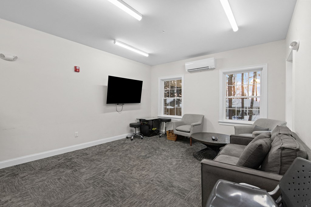 the living room of an apartment with a couch and a tv