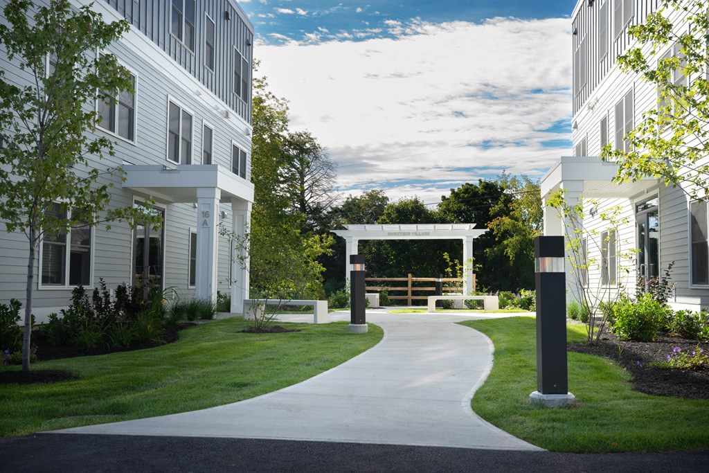 a walkway between two apartment buildings with a white archway