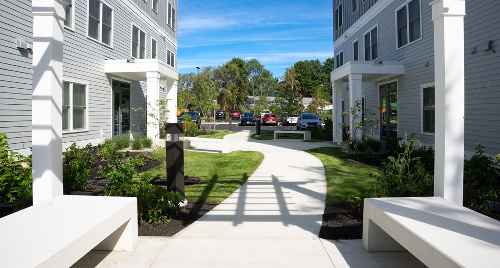 a view of a sidewalk in front of a row of houses