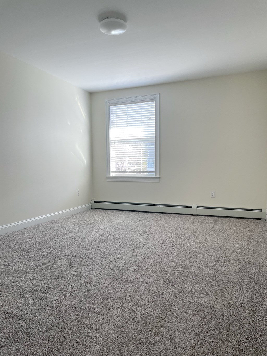 an empty room with carpet and a window