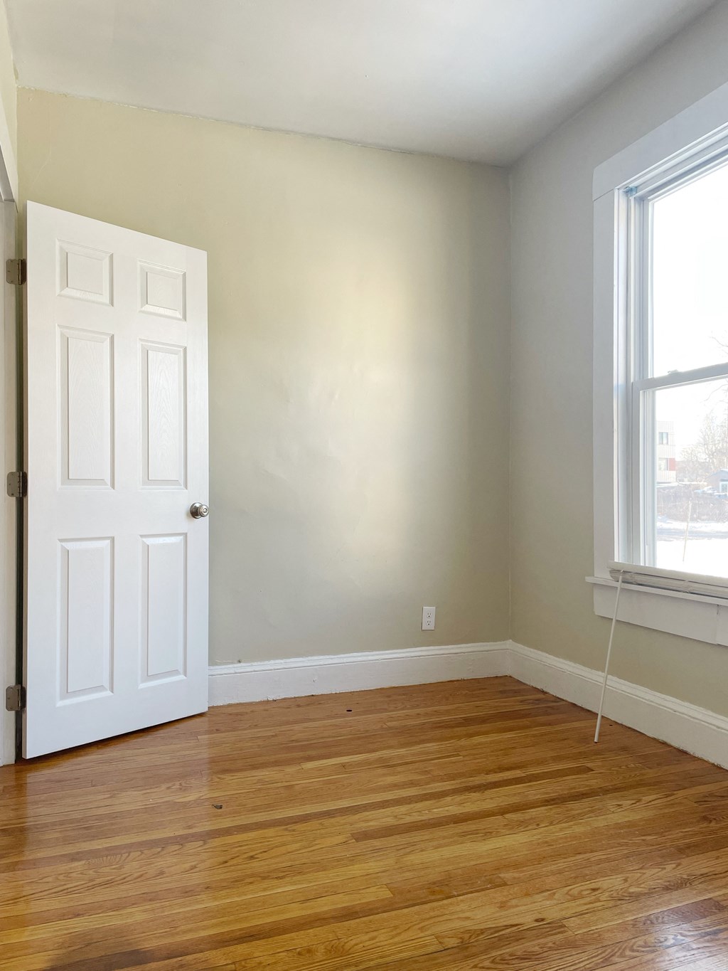 an empty room with a wooden floor and a white door