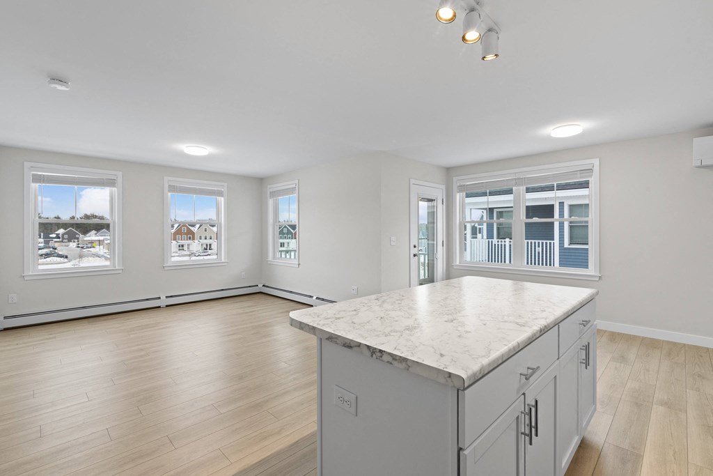 an empty kitchen with a marble counter top in a new home