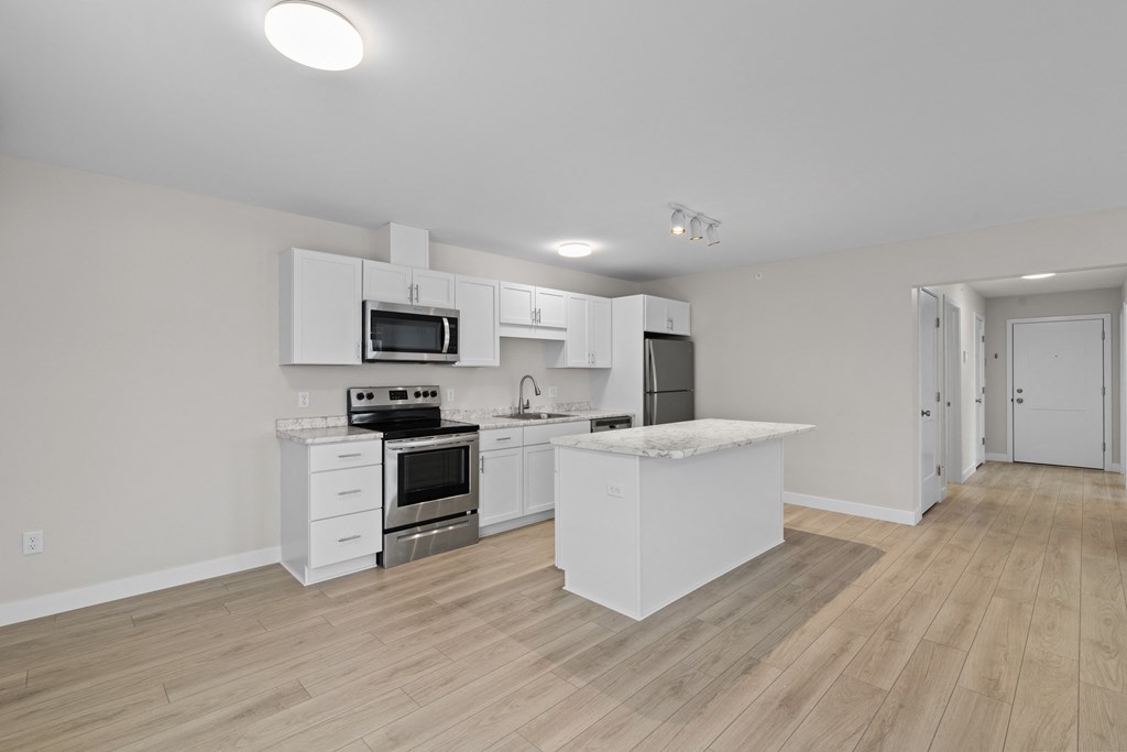 a renovated kitchen with white cabinets and stainless steel appliances