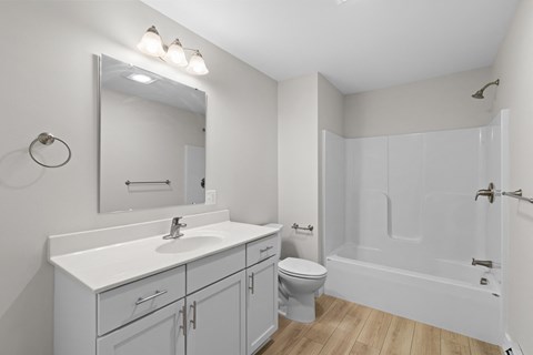 A white bathroom with a sink, toilet, and bathtub.