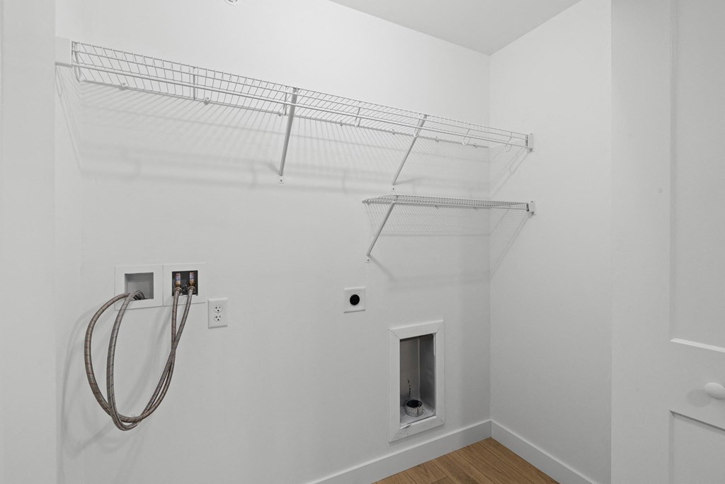a white room with a wire rack on the wall and a shower in the corner
