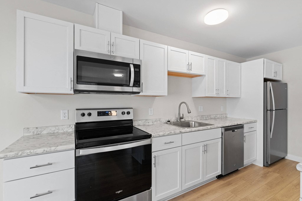 a kitchen with white cabinets and stainless steel appliances