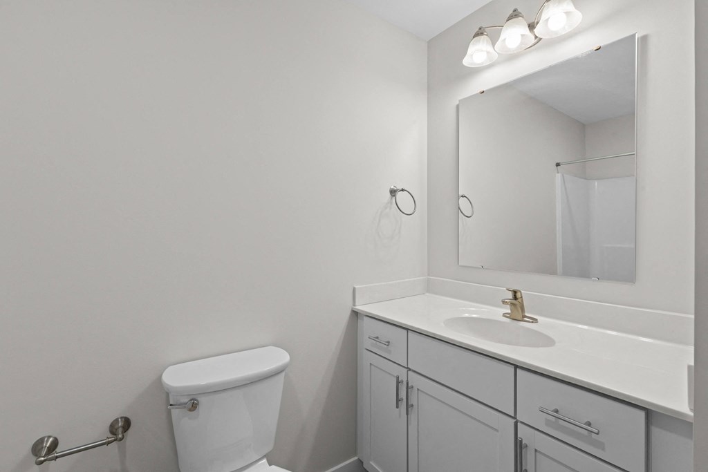a bathroom with a sink toilet and a mirror