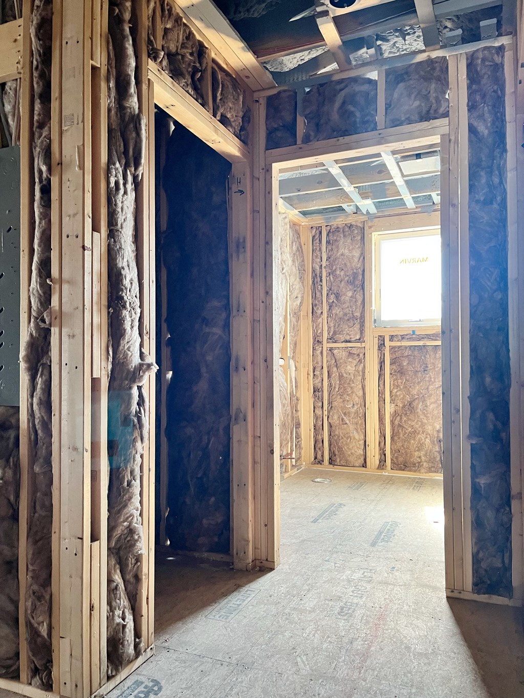 a house being remodeled with a wall of insulation and a doorway