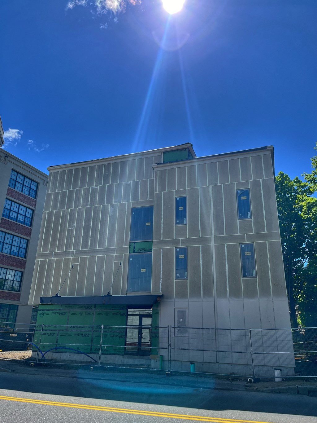a building with a glass facade with the sun shining over it