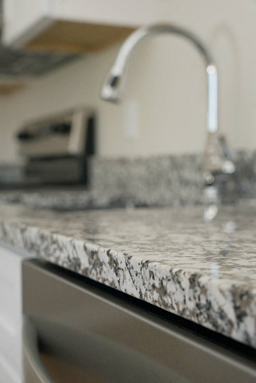 a granite kitchen counter with a sink and a faucet