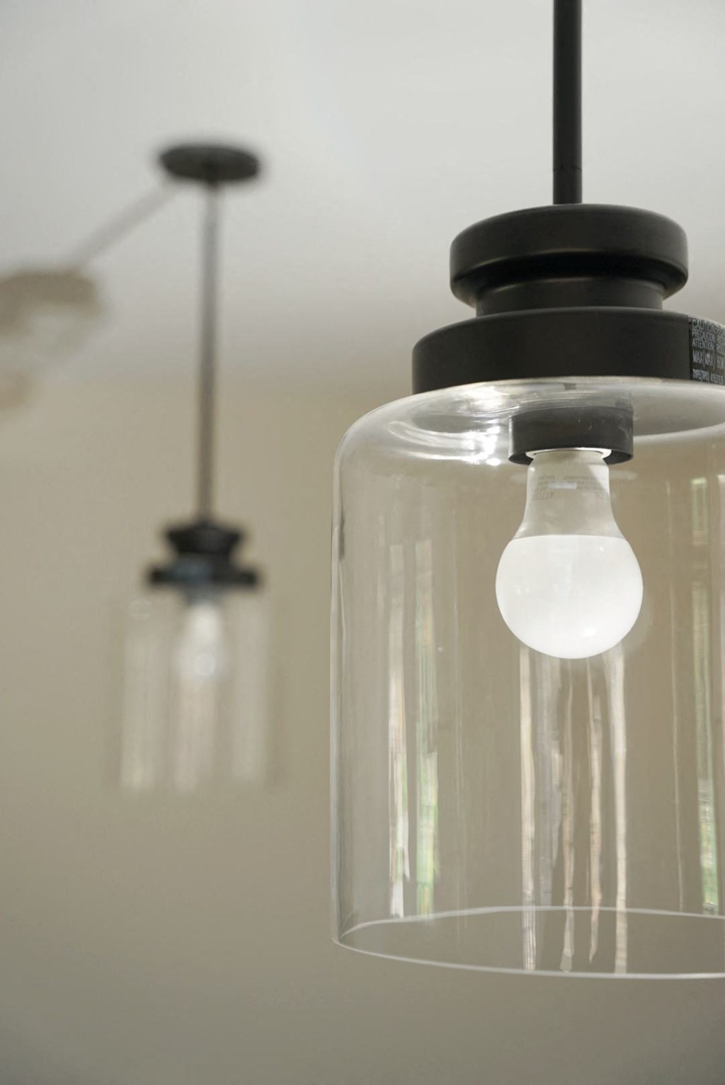 a glass light fixture hanging from a ceiling