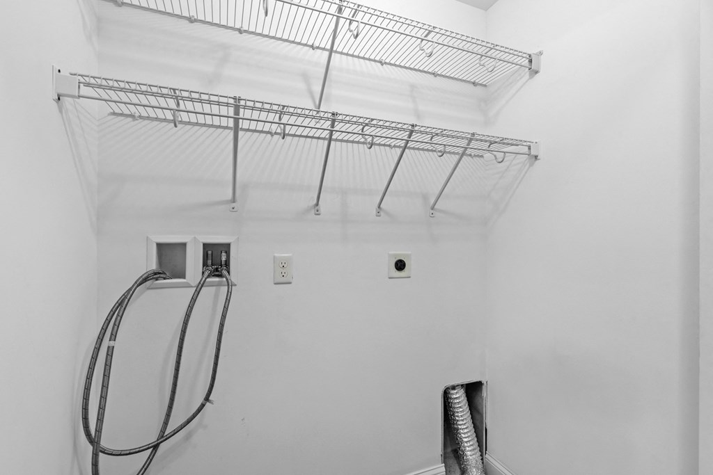 a white room with a shower and a rack on the ceiling