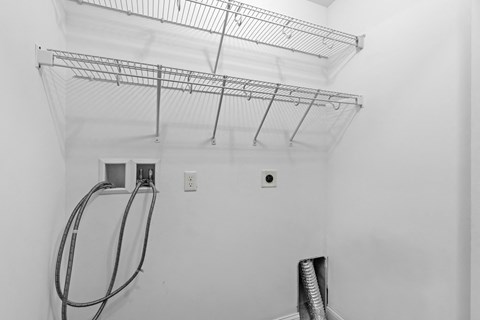 a white room with a shower and a rack on the ceiling