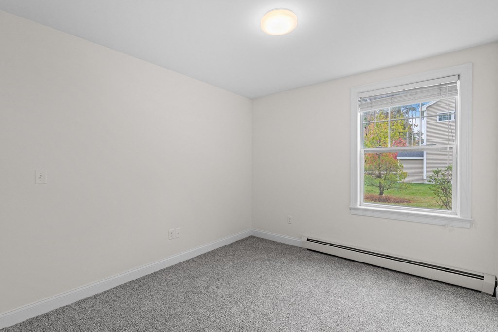 an empty room with white walls and a window