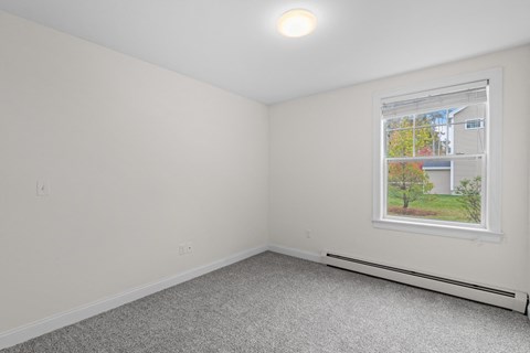 an empty room with white walls and a window