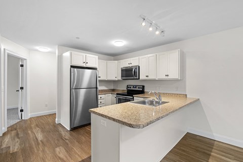 a kitchen with a granite counter top and a stainless steel refrigerator