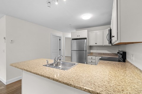 a kitchen with a granite counter top and a stainless steel refrigerator