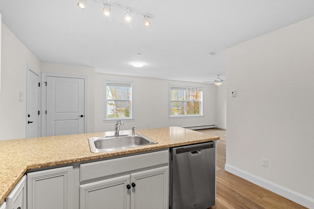 a kitchen with white cabinets and a granite counter top and a sink