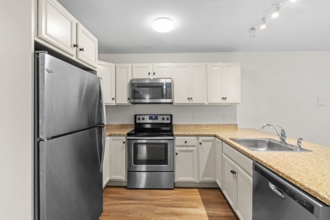 a kitchen with white cabinets and stainless steel appliances