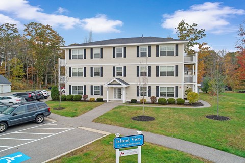 a large apartment building with cars parked in a parking lot
