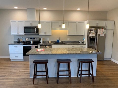 a kitchen with an island and three bar stools