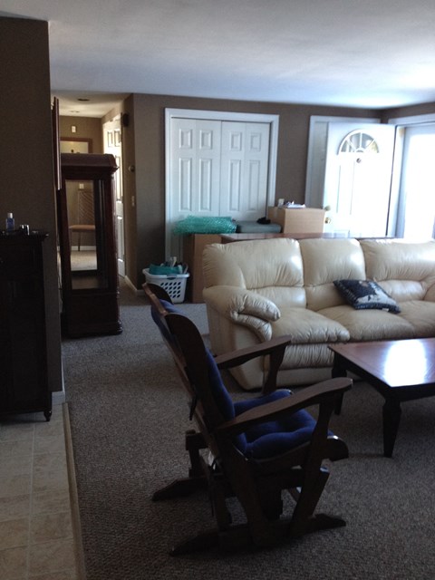 A living room with a tan couch and a wooden coffee table.