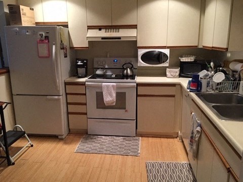 A kitchen with a refrigerator, stove, and oven.
