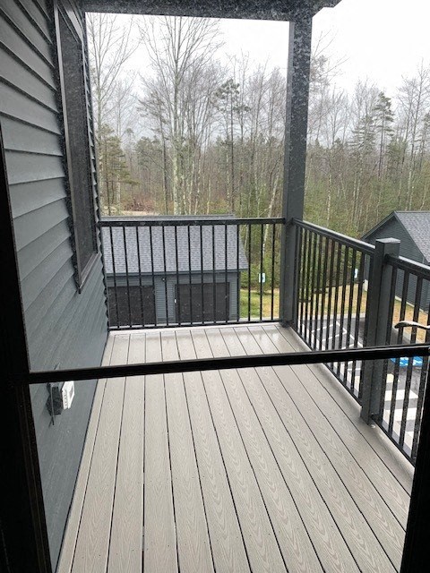 a balcony with a wooden deck and a view of trees