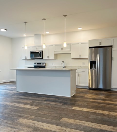 A kitchen with a white island and stainless steel appliances.