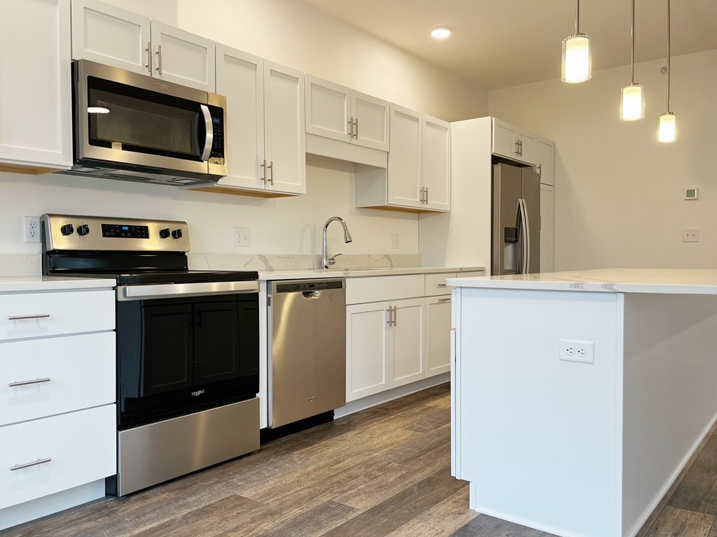 A modern kitchen with white cabinets and stainless steel appliances.
