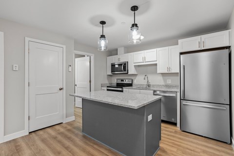 Efficient kitchen with full appliance package, granite island, and ample storage.