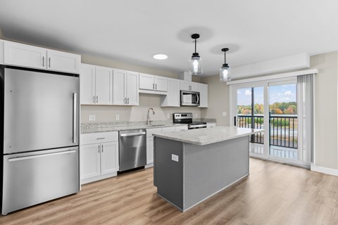 A kitchen with a refrigerator, microwave, and dishwasher.
