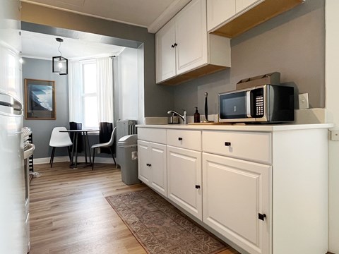 A kitchen with a white refrigerator and cabinets.