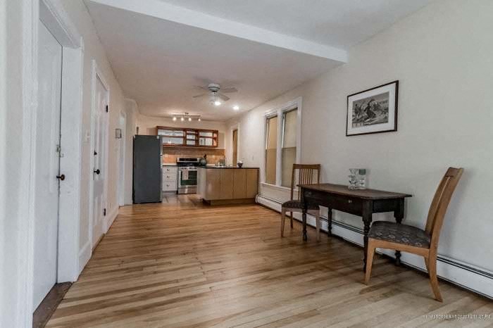 a living room and a kitchen with a table and chairs
