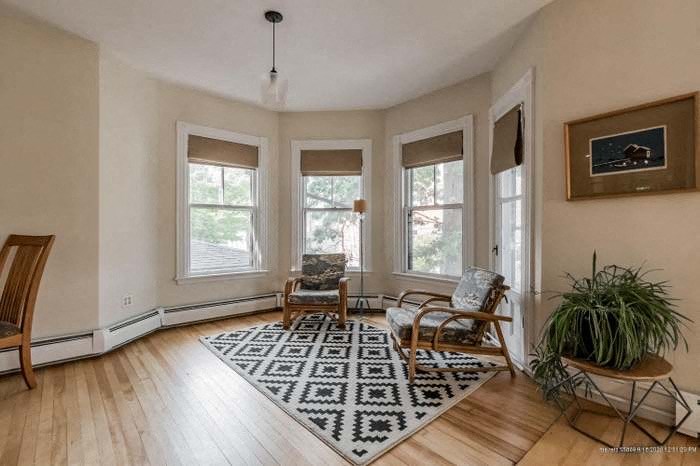 a living room with a rug and two chairs
