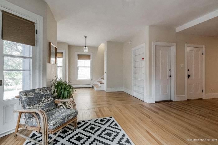 an empty living room with a chair and a rug