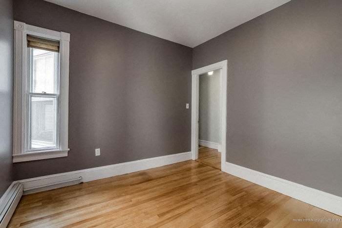 an empty room with a wood floor and a door