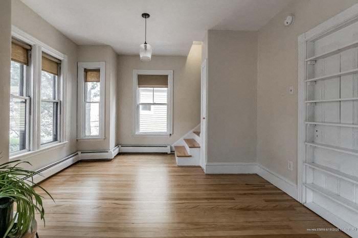 an empty living room with a wood floor and a staircase