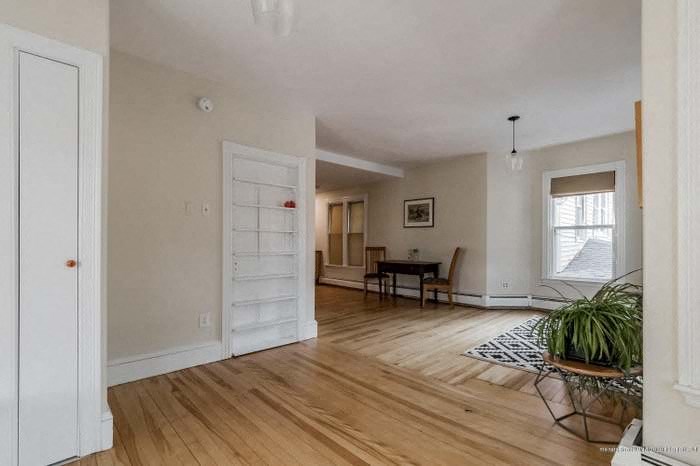 a living room with a wooden floor and a white door
