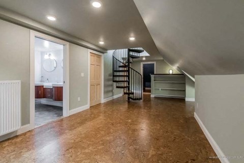 a large living room with a spiral staircase  and a bathroom
