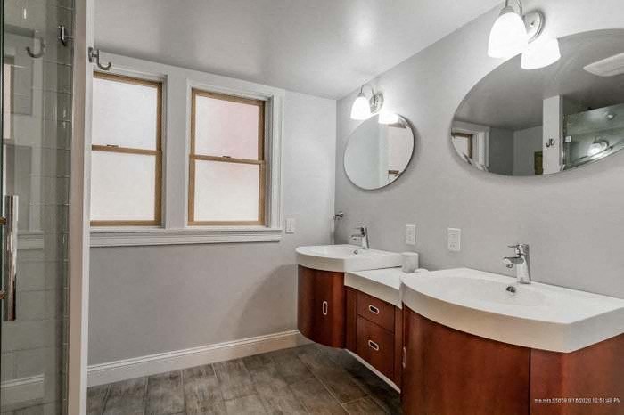 a bathroom with two sinks and a mirror and a shower