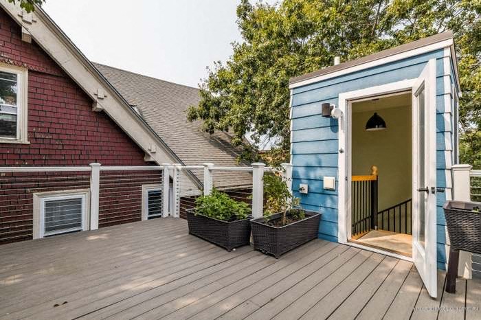 a backyard deck with a blue house and a door
