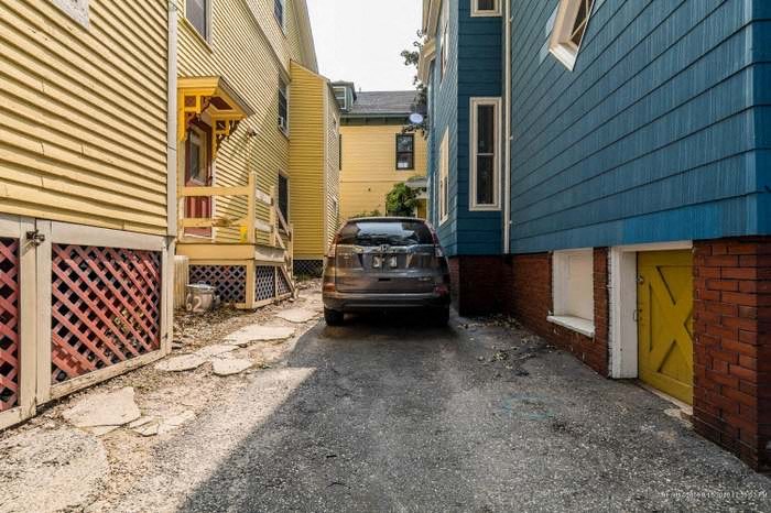 a car parked in an alley between two houses
