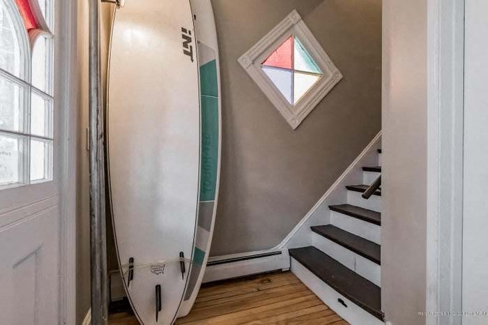 a hallway with a surfboard and a window on the wall