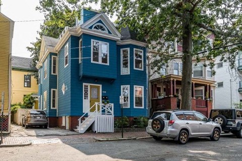 a car parked in front of a blue house
