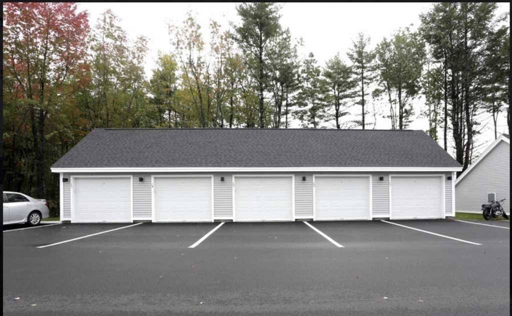 a garage with white doors and a parking lot