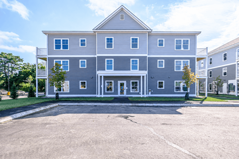 Three story residential building with gray siding at Windham Village Apartments, Maine, 04062