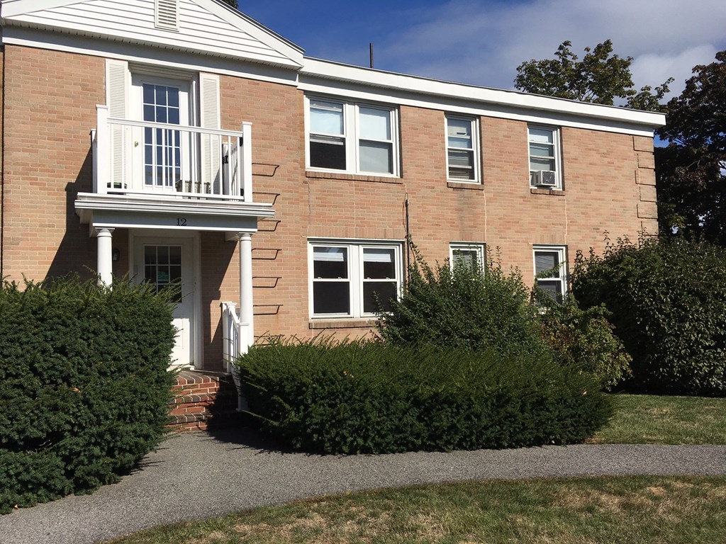 a brick house with a balcony and a walkway